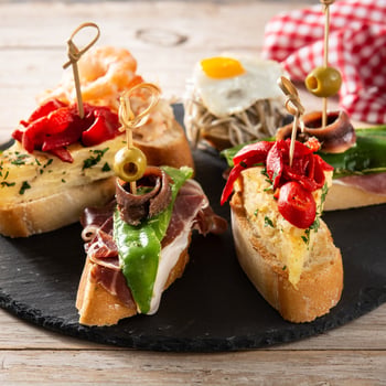 assortment-spanish-pintxos-wooden-table-typical-spanish-food