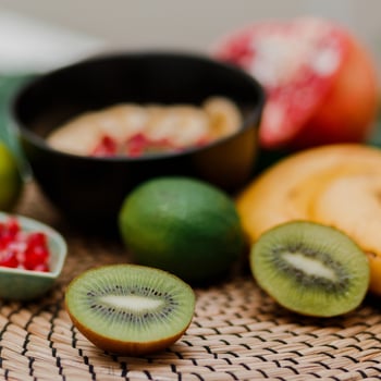 essentials-cooking-smoothie-bowl-blake-plate-topped-with-kiwi-banana-pomegranate-seeds-lime-granola-chia-seeds-healthy-breakfast-tropical-mood