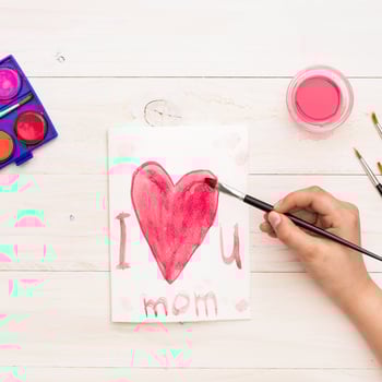 person-writing-i-love-you-mom-with-paint-brush