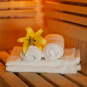 schliessen-sie-frische-handtucher-und-gelbe-lilie-der-sauna